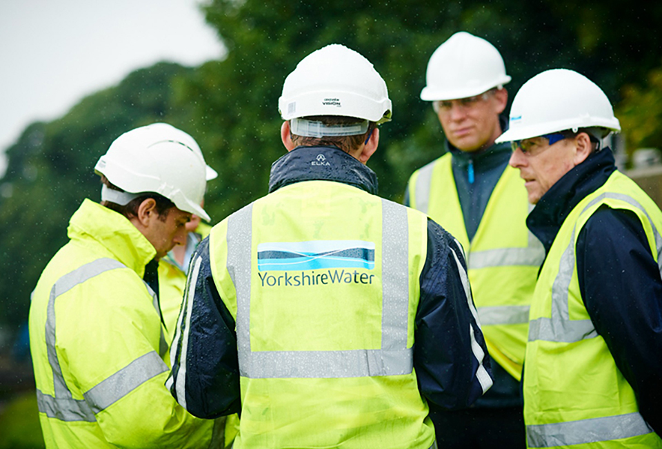 A group of Yorkshire Water colleagues dressed in PPE having a discussion