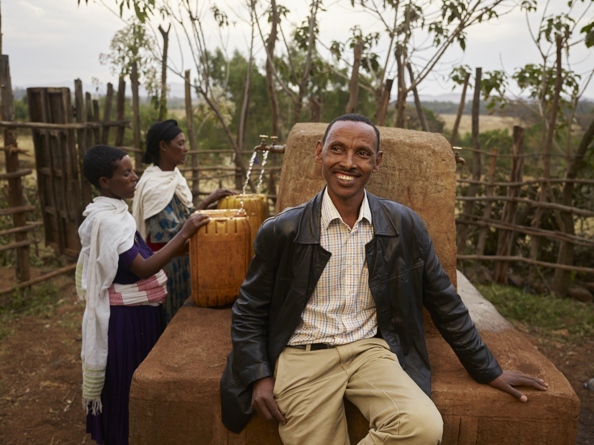 Leyew Animut by the tap stand where the community can collect clean water connected to an underground pipe system in Finote Selam, Ethiopia.