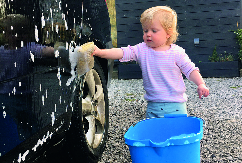 Little girl washing car