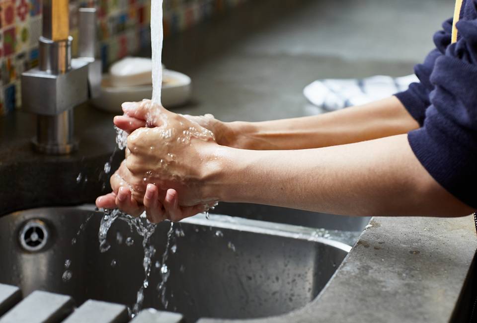 Washing hands under running tap