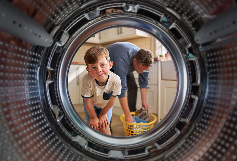 Little boy looking into washing machine