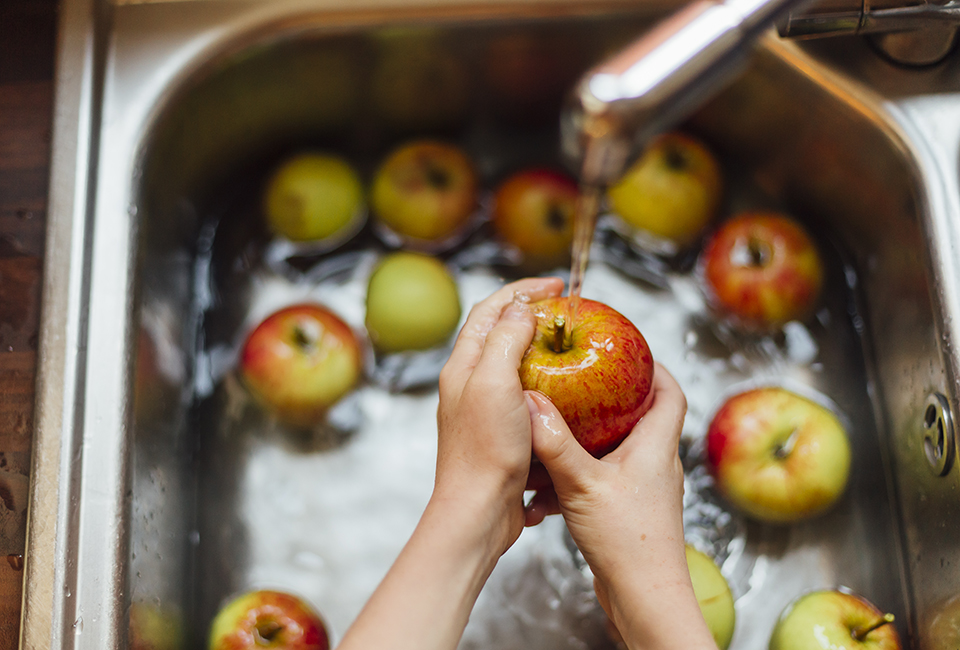 Hands washing apples